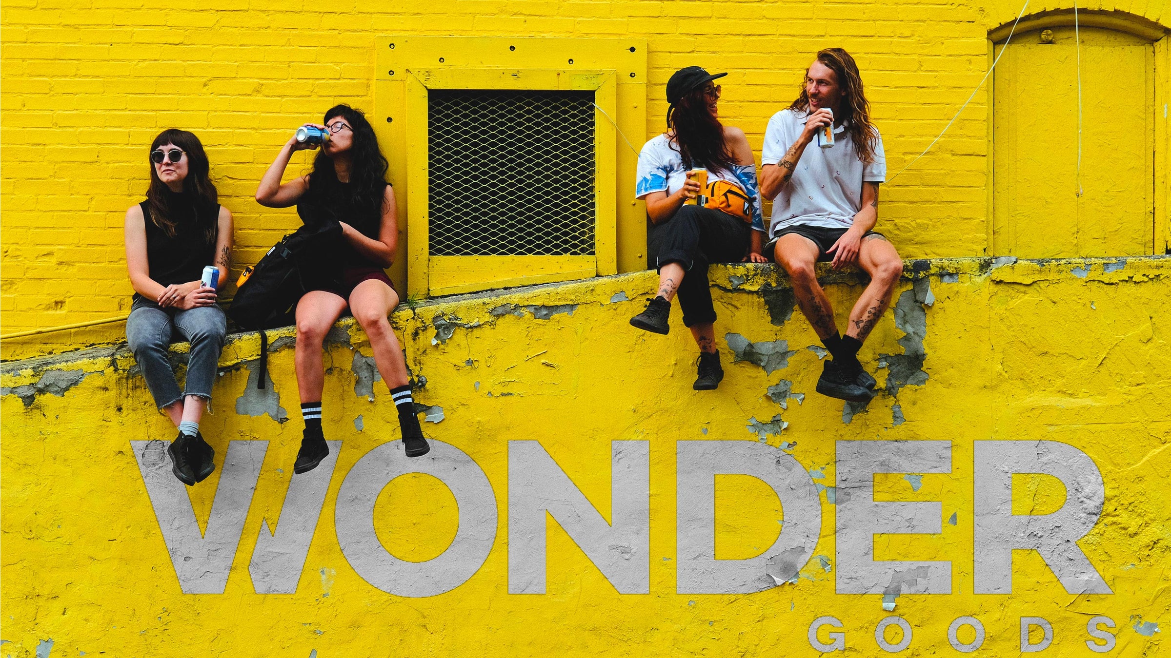 Wonder Goods crew drinking on a wall