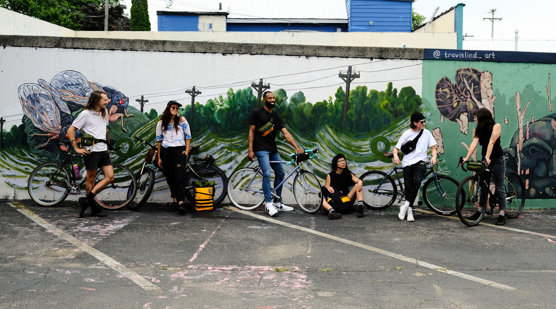 Wonder Goods crew hanging out on bikes by a mural